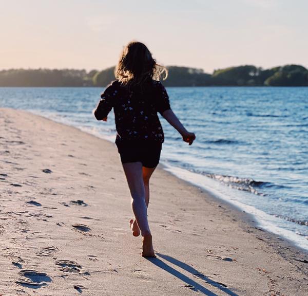 Pige løber på stranden i Middelfart
